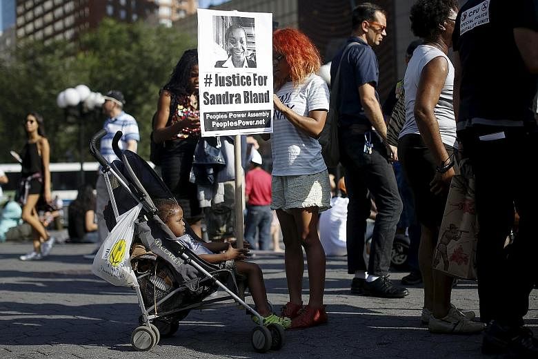 A child holding a poster of Ms Sandra Bland, who died in police custody, during a rally against police violence in New York on Wednesday. Ms Bland, a black woman, was found hanging in her Texas jail cell last week after her arrest following a minor t