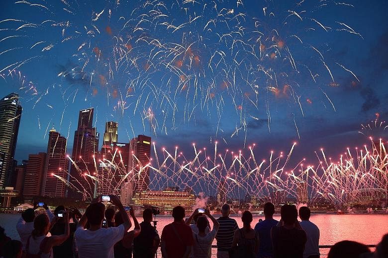 The crowd at Marina Bay Sands captivated by the fireworks display during the NDP preview yesterday. More than 15 buildings around the bay will be lit up in red and white during the parade on Aug 9. Young and old will come together to celebrate Singap