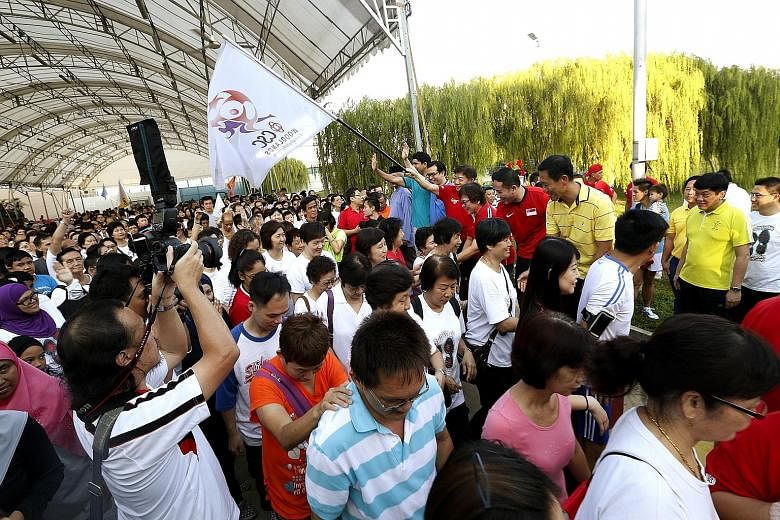 National Development Minister Khaw Boon Wan (holding flag) at the walk in tribute to Singapore's first President Yusof Ishak in Woodlands yesterday.