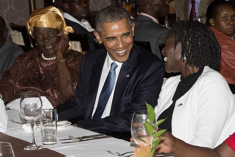 US President Barack Obama, seated between his step-grandma Mama Sarah (left) and half-sister Auma Obama, at a dinner with about three dozen relatives at his hotel in Nairobi, Kenya on Friday.
