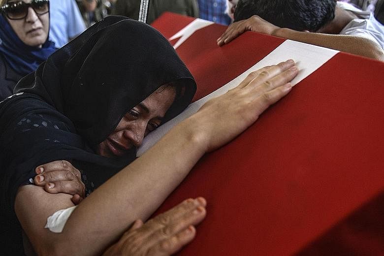The wife of Turkish soldier Mehmet Yalcin Nane weeping on his coffin in the city of Gaziantep. His death has prompted a more aggressive anti-ISIS stance by Turkey.