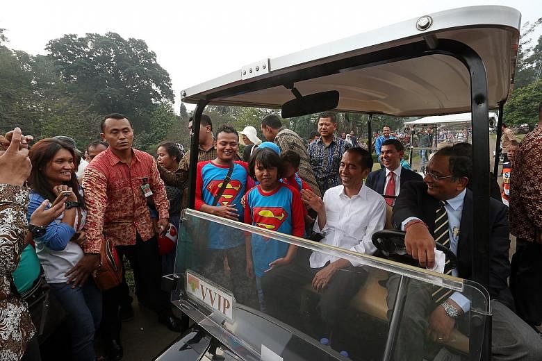 Members of the public swarming around President Joko Widodo's buggy during a ride around the Bogor Palace compound with The Straits Times team yesterday. Mr Joko uses Bogor Palace as his principal office, rather than the Merdeka Palace in Jakarta.