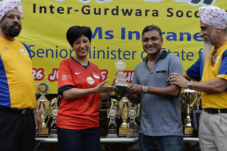 Senior Minister of State for Law and Education Indranee Rajah presenting coach V. Sundramoorthy with a lifetime achievement award from the local Sikh community for his contributions to Singapore football. With them are Gurdip Singh Usma (left), vice-