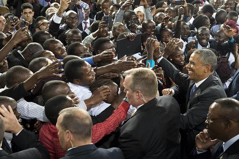 Mr Barack Obama (right) greeting the crowd after delivering his address to Kenyans at the Safaricom Indoor Arena in Nairobi yesterday. Much of his speech stressed his affinity with young Kenyans, a vital group in a country where 60 per cent of the po