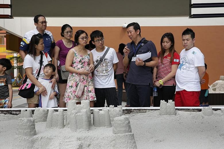 Parent Ong Hai Yong (in grey shirt), with other parents who were checking out West Spring Primary School during an open house this month. The senior quality inspector decided to enrol his daughter at the school after checking out its facilities and s