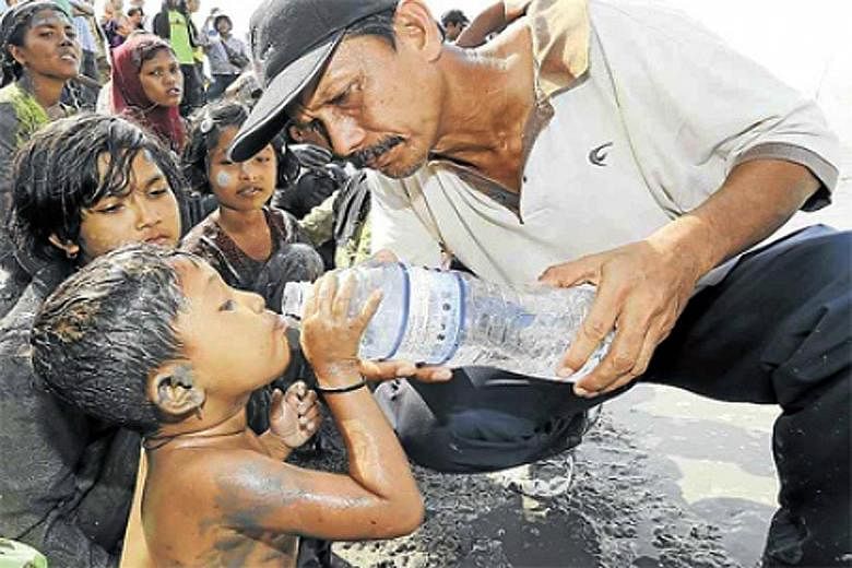 A villager helping a Rohingya boy in Alor Star, Malaysia. The country has been criticised for the Rohingya refugee crisis in South-east Asia.