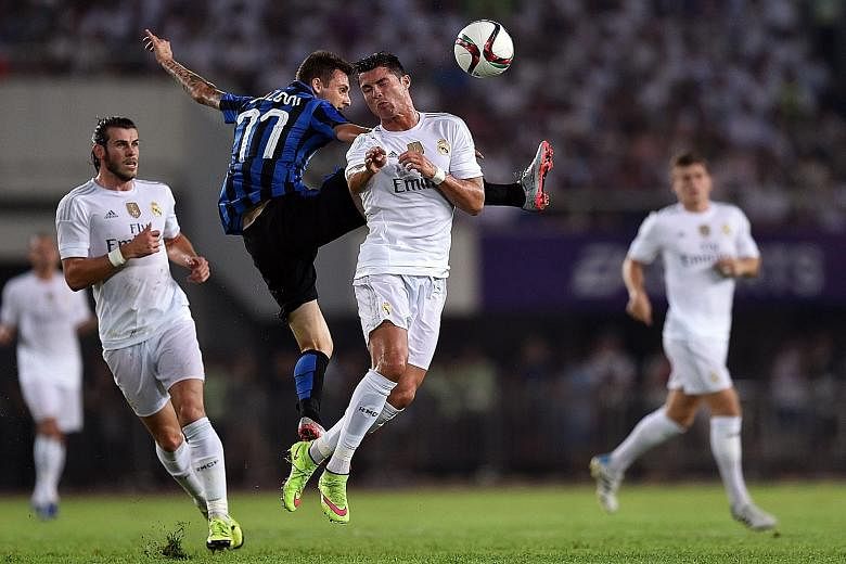 Real Madrid forward Cristiano Ronaldo (centre, in white) vying for the ball with Inter Milan's Jonathan Biabiany. Real won 3-0.