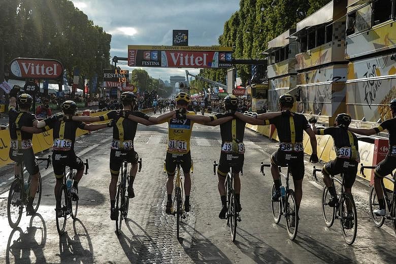 Chris Froome (centre), wearing the overall leader's yellow jersey, and his Sky team-mates head to the finish line to clinch the British team's third victory in four years. This year's Tour has been dogged by talk of possible doping by Froome but the 