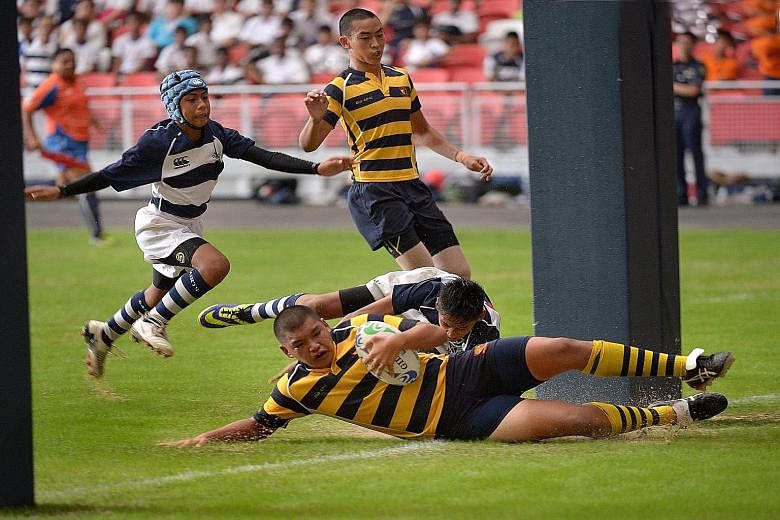 Anglo-Chinese School's (Independent) Tristan Yeow (with ball) scoring the first of his team's four tries as they beat St Andrew's School 28-8 in the C Division rugby final played at the new National Stadium on Aug 26 last year. Playing the occasional