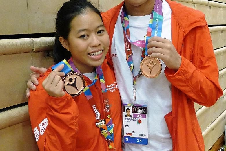 Singapore swimmers Danielle Moi and Han Liang Chou with their medals.