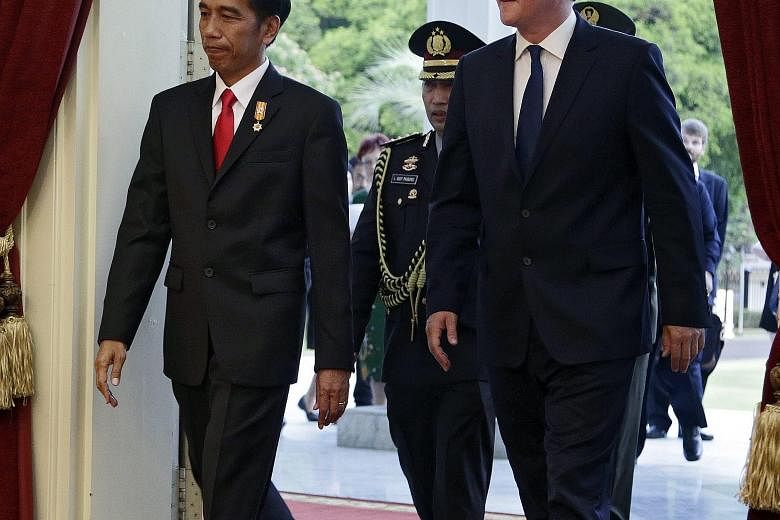 Indonesian President Joko Widodo (left) and British Prime Minister David Cameron arriving at the Presidential Palace in Jakarta yesterday. Mr Cameron arrives in Singapore today.