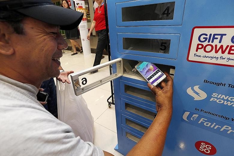 Mr Ridwan Hashim, 51, a delivery driver, charging his smartphone at a charging station in nex mall yesterday.