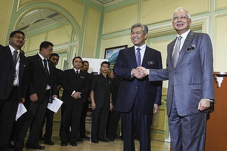 Malaysian Prime Minister Najib Razak (right) with his new deputy, Datuk Seri Ahmad Zahid Hamidi, after a press conference on the reshuffling of his Cabinet at the Prime Minister's Office in Putrajaya yesterday. The reshuffle was widely condemned by g