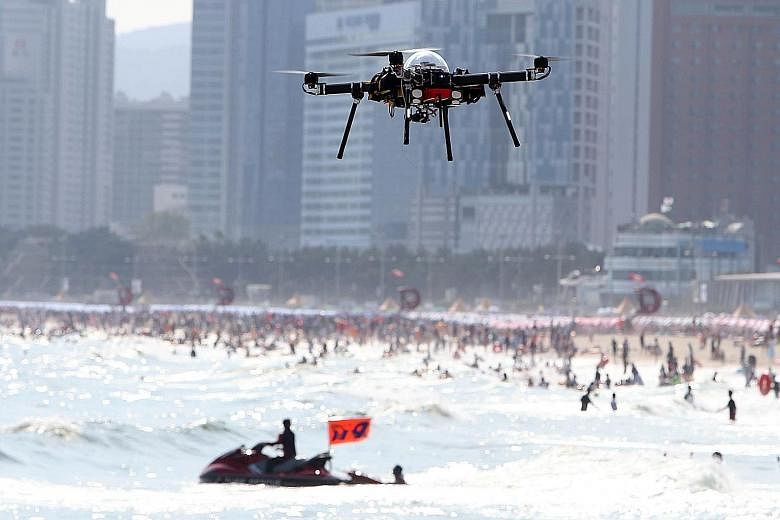 A public safety drone hovering above Haeundae beach in Busan yesterday. The Busan city government is using the drones at the popular beach as one of its safety measures to prevent drownings during the busy school holiday period, which typically runs 