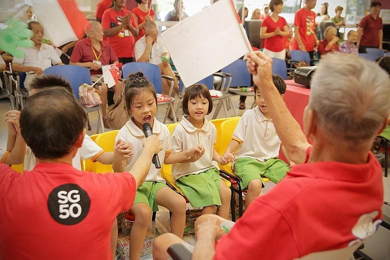 Kindergarten children from My First Skool singing SG50 songs with seniors from NTUC Health's Silver Circle Senior Care Centre, in an inter-generational bonding event yesterday. For about three months, 50 senior citizens from the centre and 50 childre
