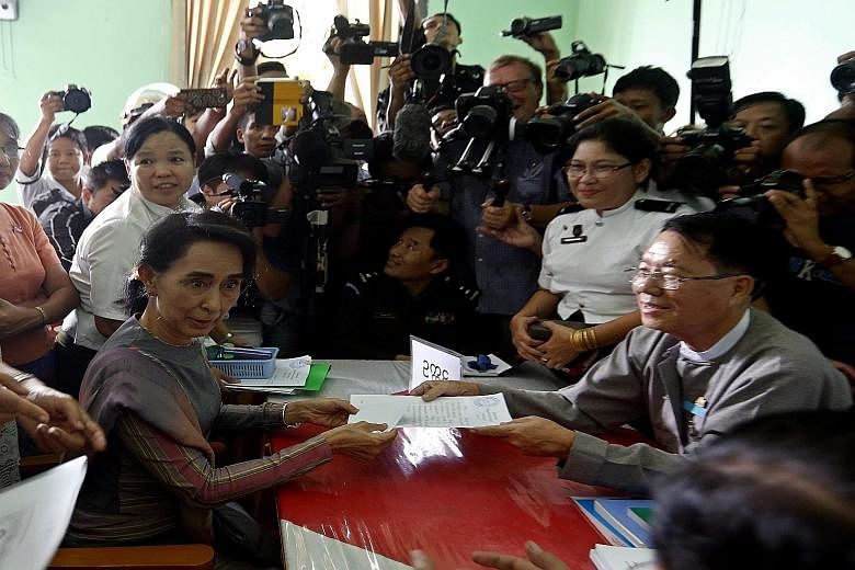 Myanmar opposition leader Aung San Suu Kyi at an Election Commission office in a Yangon township yesterday to submit an application to run in the Nov 8 general election.