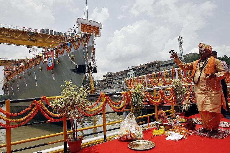 A Hindu priest blessing the Kavaratti, one of the Indian Navy's four anti-submarine warfare corvettes, during its launch at a dockyard in Kolkata. India plans to spend at least US$61 billion (S$83 billion) on expanding its navy's size by about half i