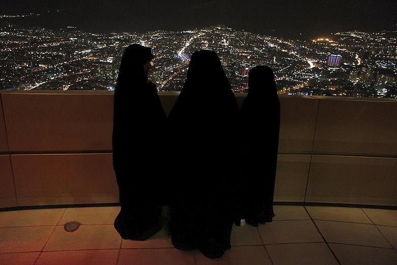 Iranian women waiting for a ceremony in Teheran to mark the anniversary of the country's Islamic Revolution in this February 2011 picture. That revolution set up a global competition between Shi'ite Iran and Sunni Saudi Arabia for leadership of the M