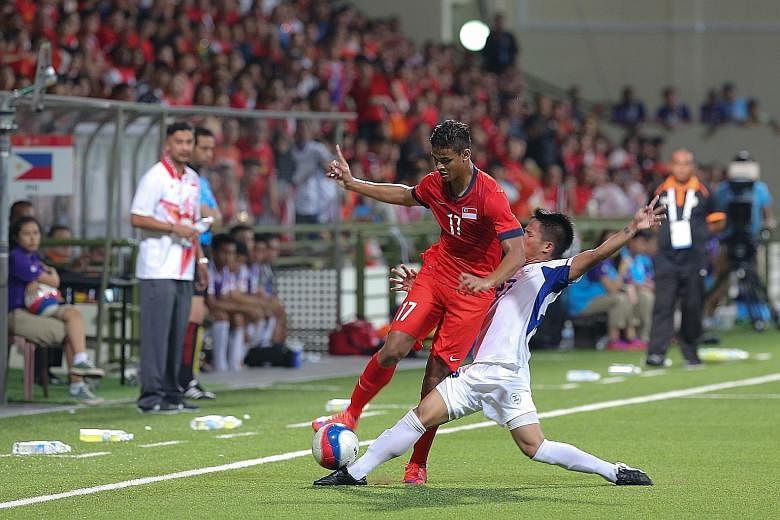 Singapore U-23 forward Irfan Fandi charging down the flanks during the SEA Games football match against the Philippines, as his coach Aide Iskandar (in white) looks on. The Young Lions' failure to make the SEA Games semi-finals was a bitter disappoin