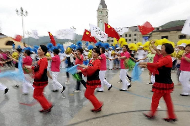 Local residents dance during a rehearsal for a possible celebration today at a square in Chongli county, administered by Zhangjiakou, which is jointly bidding with the capital Beijing to host the 2022 Winter Olympic Games. Beijing, which hosted the 2