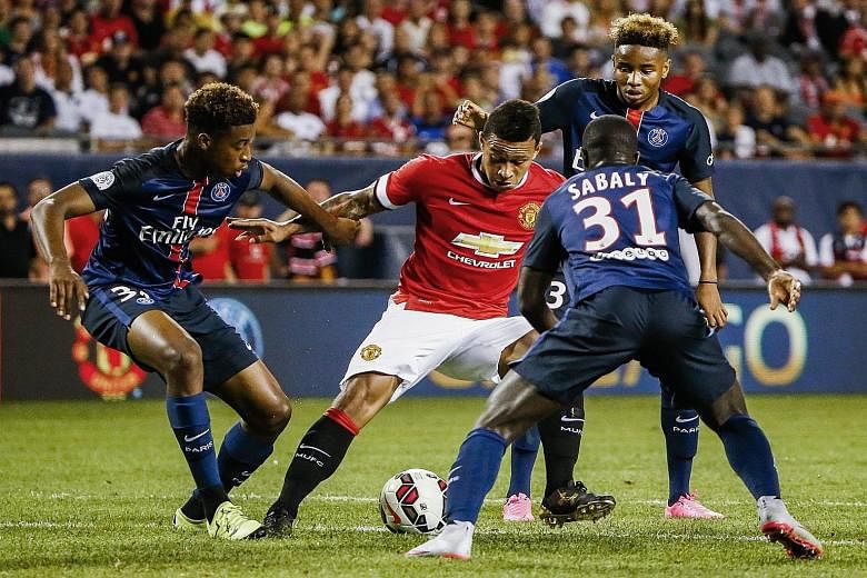 Manchester United forward Memphis Depay (in red) finds the going hard, surrounded by three Paris Saint-Germain players, in an International Champions Cup match in Chicago on Wednesday. In the game which the Red Devils lost 0-2, goalkeeper David de Ge