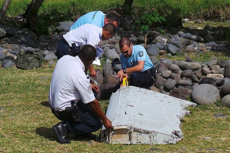 French police inspecting a piece of plane debris found in Saint-Andre, on Reunion island, on Wednesday. France's BEA said it was examining the debris, in coordination with Malaysian and Australian authorities.