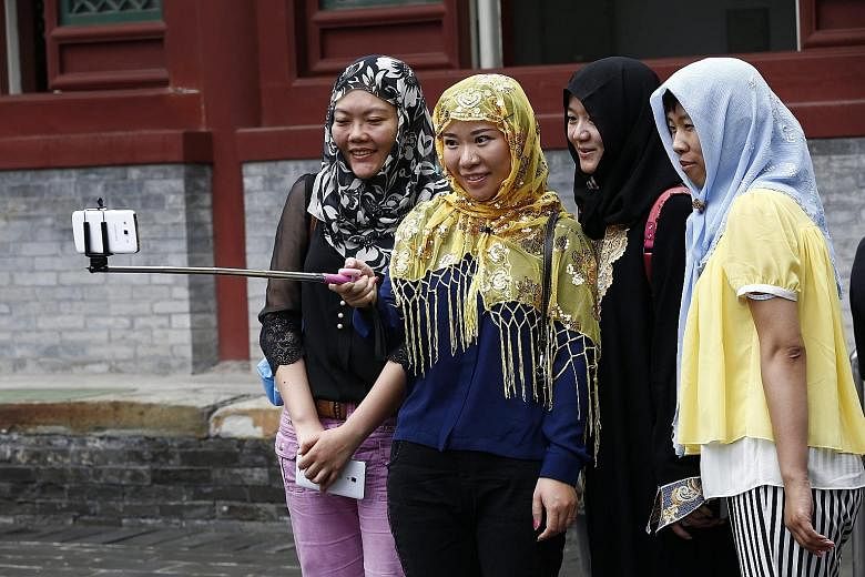 Muslims taking a photograph after morning prayers outside the Niujie Mosque in Beijing on July 18. Islam is one of China's fastest growing faiths, and the proportion of Muslims in the country is expected to hit 2.7 per cent in 2050, from 1.8 per cent