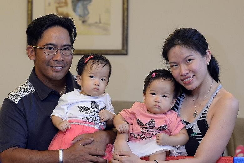 Mrs Regine Sahetapy and her husband Carl with their twin daughters Gabrielle (left) and Noelle, who were conceived naturally and were born in September last year.