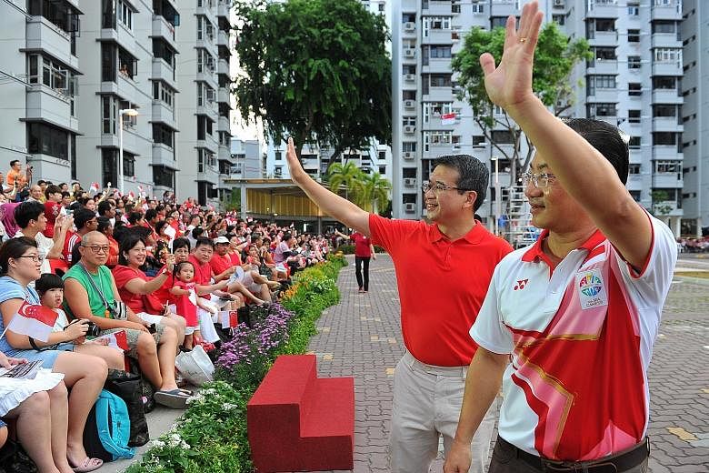 Marine Parade GRC MP Seah Kian Peng (right) and Mr Edwin Tong greeting residents at a National Day celebratory parade in Marine Terrace yesterday.