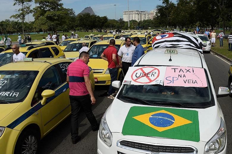 Hundreds of taxi drivers blocking the avenue which links the south and centre of Rio de Janeiro, Brazil, on July 24, to protest against Uber, a mobile phone application to hail taxis.