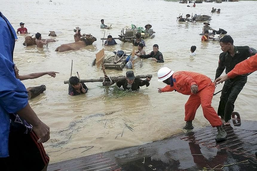 Rescue workers helping farmers to flee flooded areas with their cattle near the town of Thayet in the Magway region.