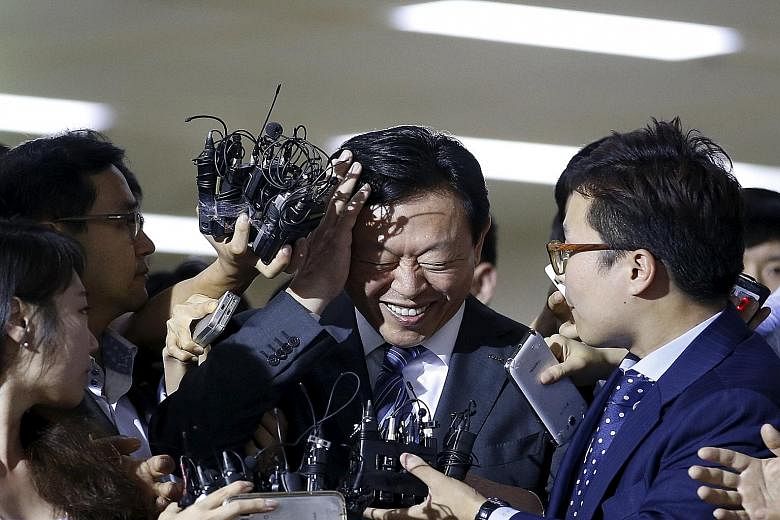 Mr Shin Dong Bin (centre), the younger son of Lotte founder Shin Kyuk Ho, surrounded by the media in Seoul yesterday.