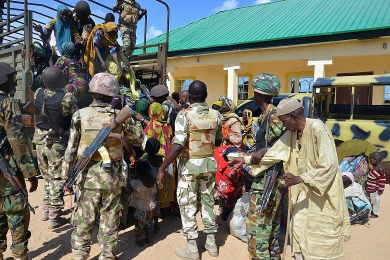 Soldiers from the Nigerian military assisting the people rescued from Boko Haram camps in Maiduguri in north-eastern Nigeria.