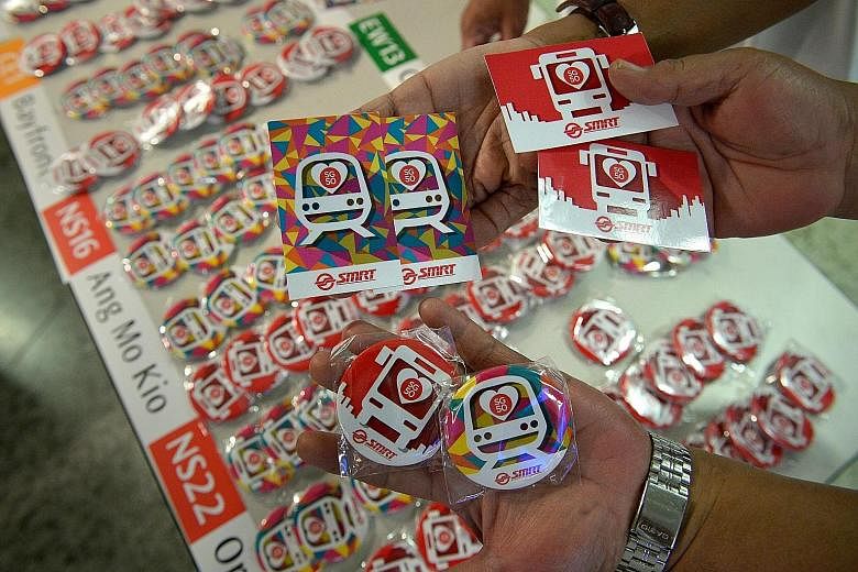 Some of the badges and EZ-link card stickers to be given away. On Sunday, commuters can board any public bus without having to tap in with their fare cards. Gantries at all MRT stations will also be kept open.