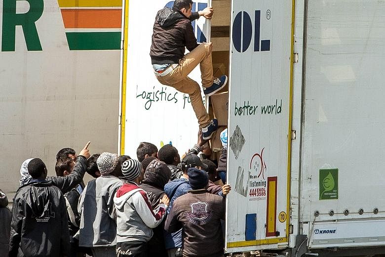 Migrants climbing into the back of a lorry on a highway leading to the Eurotunnel, which connects France to Britain. Britain's reputation as a "soft spot" for migrants remains undiminished.