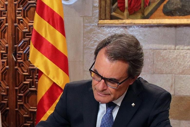 Catalan President Artur Mas signing a decree in Barcelona on Monday, calling early parliamentary elections.