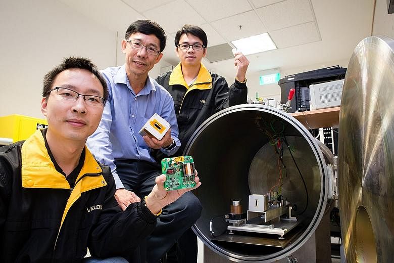 NTU's Associate Professor Low Kay Soon (centre) with his researchers on the project. The university worked with Japan's Kyushu Institute of Technology on a nanosatellite which will be delivered to the ISS for launch next year.