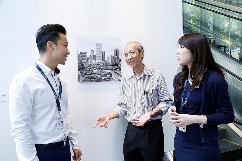 Pioneer generation artist Loke Hong Seng sharing his stories of Singapore in the 1960s with UOB employees at his exhibition at the UOB Art Gallery, as part of the bank's activities to celebrate SG50. The bank is giving about 7,500 employees ranked vi