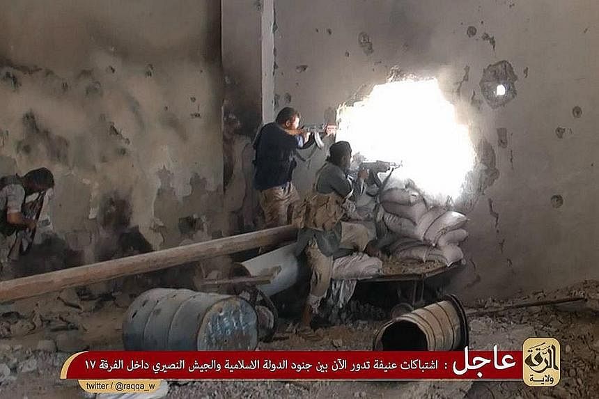 An image made available last year allegedly shows ISIS members firing at positions of pro-regime Syrian troops in rebel-held Raqa city.