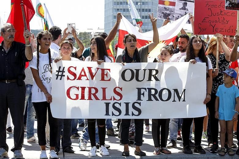 Protesters with banners and placards at a pro-Yazidi rally on the Place des Nations in front of the UN's European headquarters in Geneva, Switzerland, on Monday. ISIS has made a particular practice of enslaving those it has conquered who are not Sunni Mus