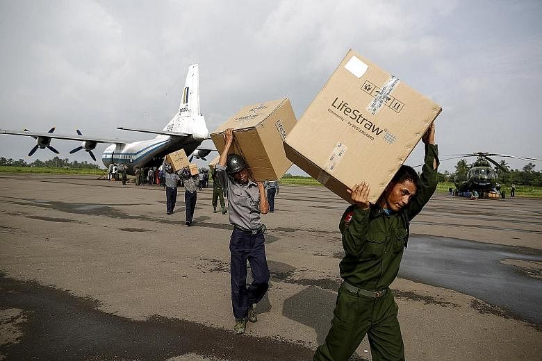 Soldiers and rescue workers unloading aid from a plane in Sittwe airport, Rakhine state, yesterday. The full nationwide picture remains unclear, with communications across the vast but poor country severed by the floods.