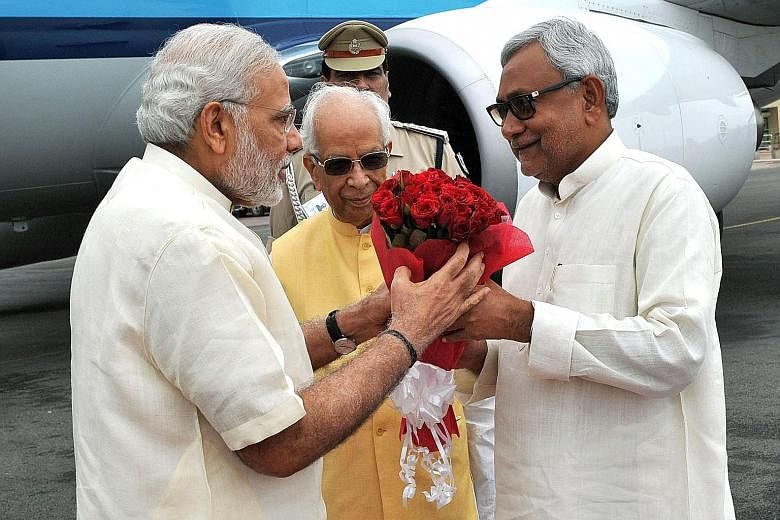 PM Narendra Modi (left) welcomed by Bihar Chief Minister Nitish Kumar upon Mr Modi's arrival in Patna, Bihar, on July 25. With them is Bihar Governor Keshari Nath Tripathi. Mr Modi's BJP alliance will face Mr Kumar's alliance in the state's elections
