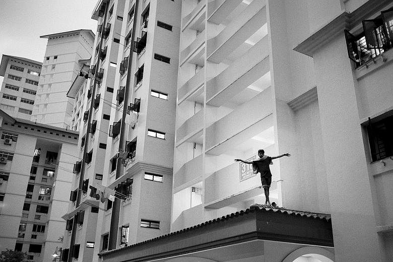 A boy walking on a ledge at a block of HDB flats in Ang Mo Kio from Bernice Wong's photo series School Of Hard Knocks. (Left above) A shot from Tay Kay Chin's photo series Made In Singapore, which traces the life of Bangladeshi foreign worker Salim J