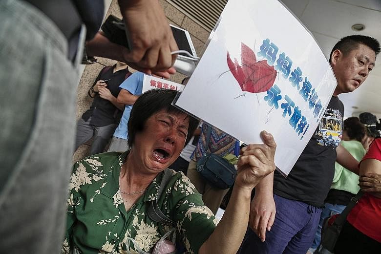 A woman whose loved ones were on Flight MH370 in tears outside the Malaysia Airlines (MAS) office in Beijing yesterday. More than 20 family members of passengers held a protest outside the MAS office, accusing the airline of hiding the truth in a "po