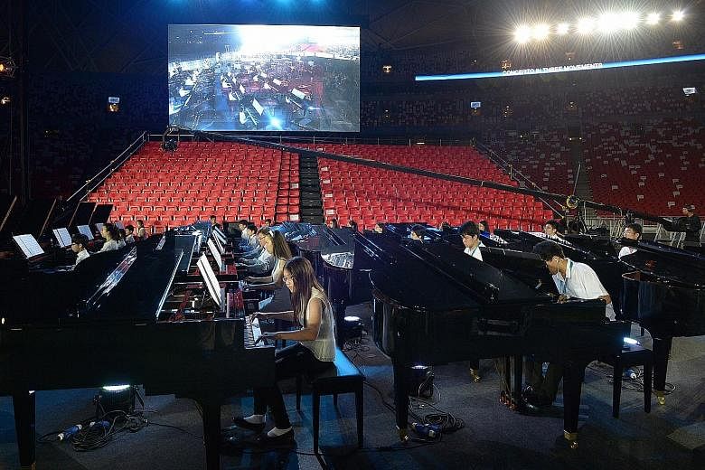 Some of the pianists, part of a contingent of 50 led by Chinese maestro Lang Lang, during rehearsals last night in preparation for the Sing50 concert tonight at the National Stadium. The musicians, aged seven to 52, will all play on 50 Steinway-desig