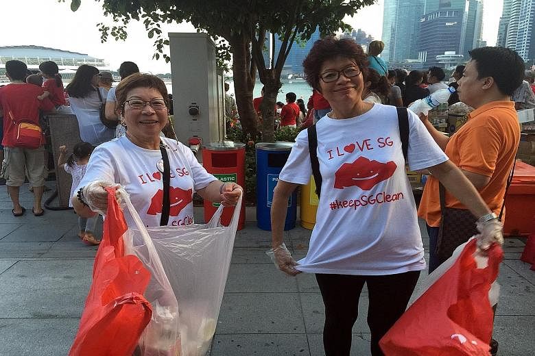 Volunteers from the Singapore Glove Project, a community movement to keep Singapore clean, picking up trash at the Esplanade during the National Day Parade preview last Saturday.