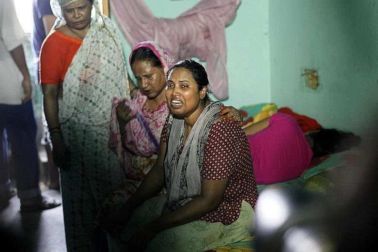 The wife (right) of murdered Bangladeshi blogger Niloy Chakrabarti, who was known for his atheist views in the Muslim- majority country, weeping at their home in Dhaka yesterday.