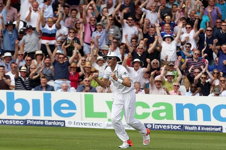 England fielder Stuart Broad celebrates after taking a catch to dismiss Australian batsman David Warner for 64.