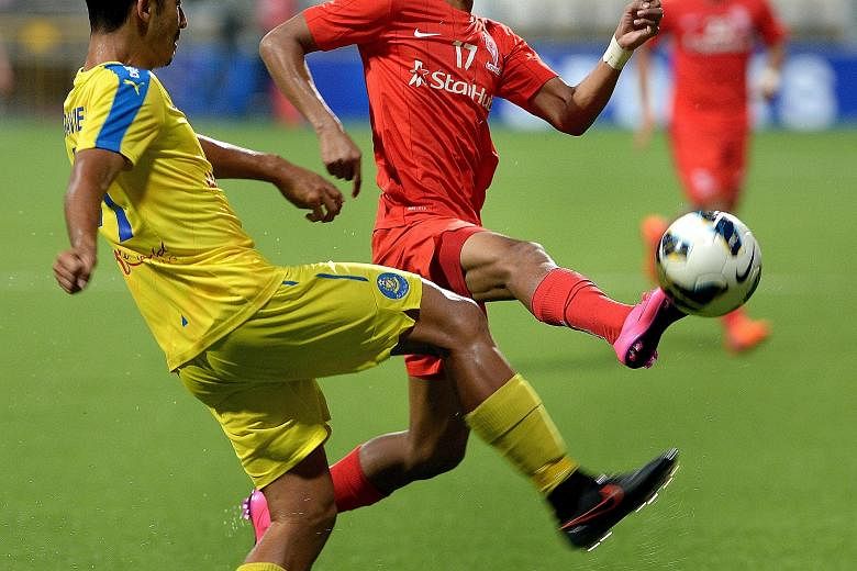 LionsXII's Faris Ramli (in red) and Pahang's Matthew Davies vying for the ball. Faris' double took his MSL season's tally to eight goals.
