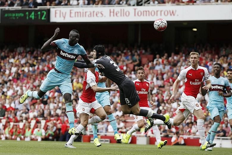 West Ham's Senegalese midfielder Cheikhou Kouyate gets to the ball ahead of Arsenal goalkeeper Petr Cech to head in the opening goal. Argentinian Mauro Zarate sealed the points in the second half.